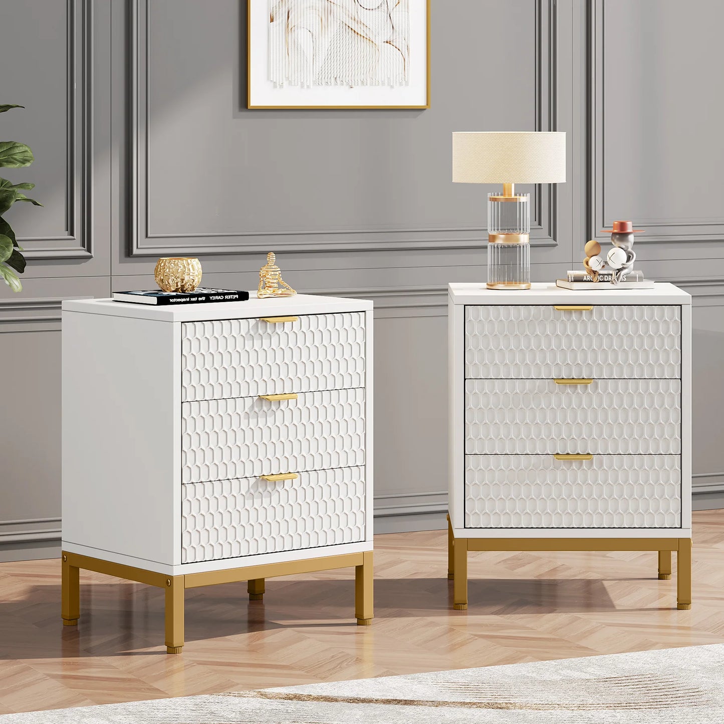 Two white nightstands with gold accents in a room with gray walls and a lamp.