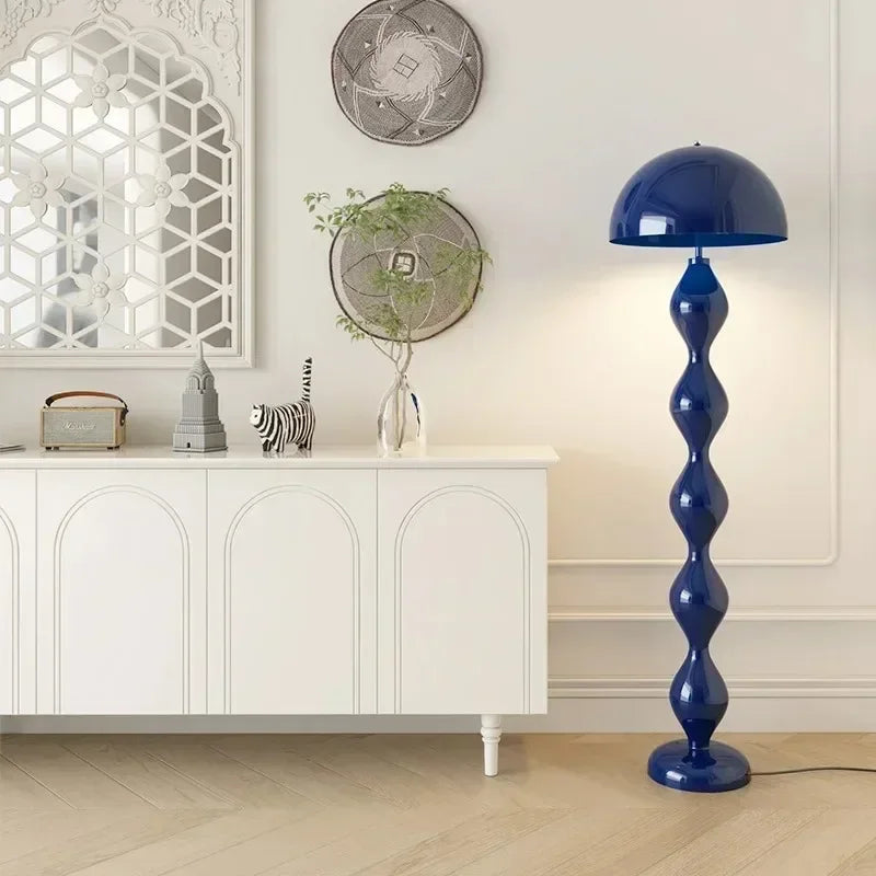 Blue floor lamp in a room with white cabinet and decorative items