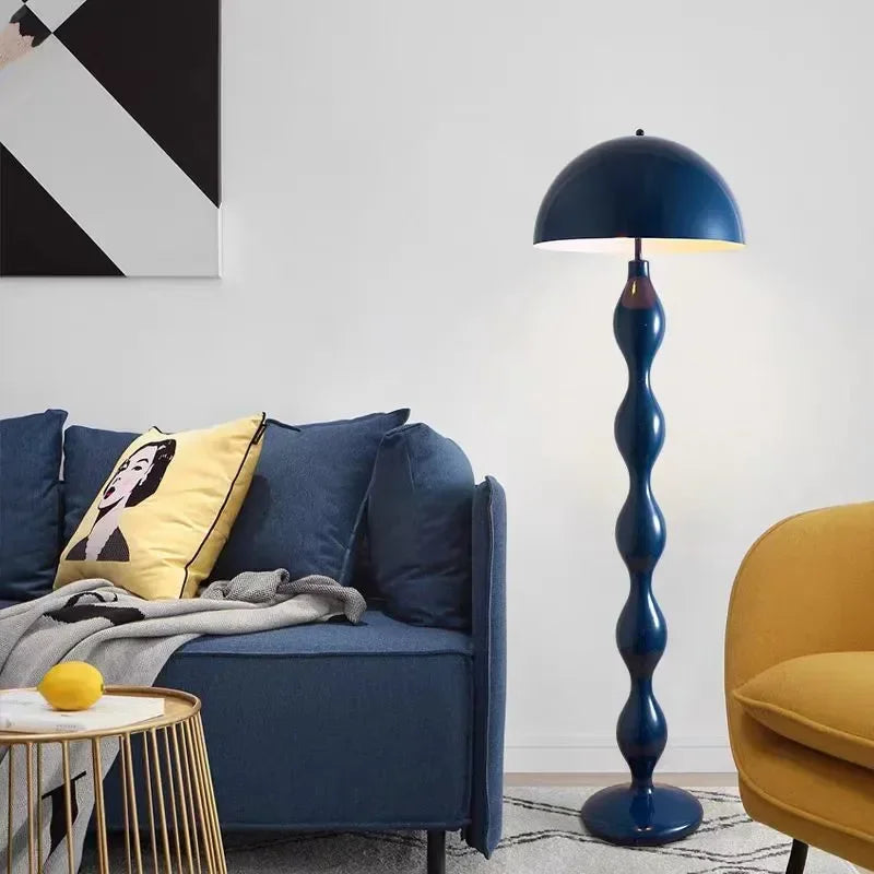 Modern living room with a blue floor lamp, blue sofa, and yellow chair.