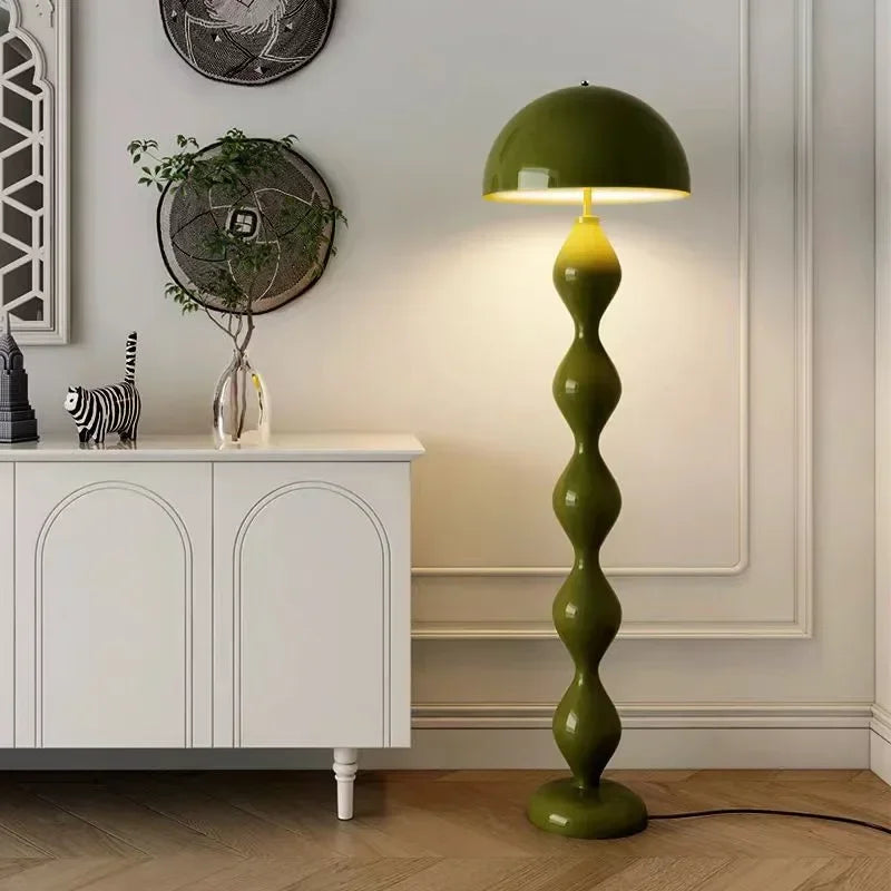 Green floor lamp in a room with a white cabinet and decorative items.