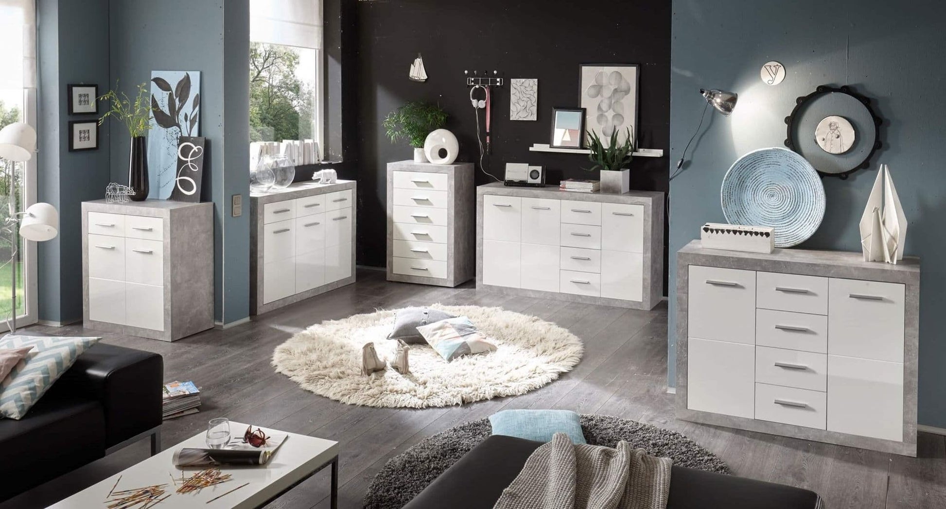 Modern living room with white and gray furniture, including dressers and a coffee table.