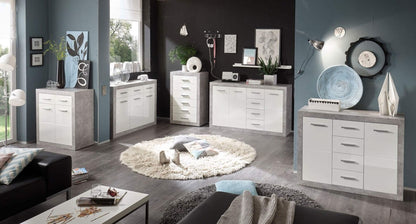 Modern living room with white and gray furniture, including dressers and a coffee table.