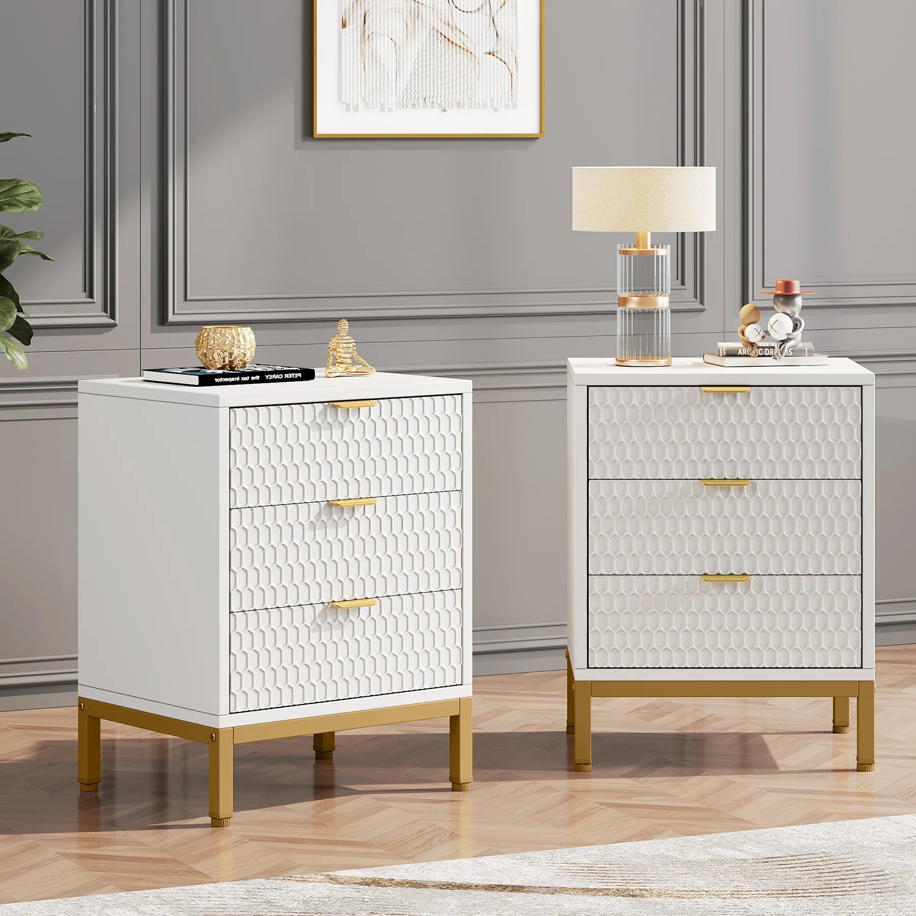 Two white nightstands with gold accents in a room with gray walls and a lamp.