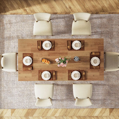 Farmena Dining table set with plates, cutlery, and a vase of flowers, surrounded by chairs on a wooden floor.