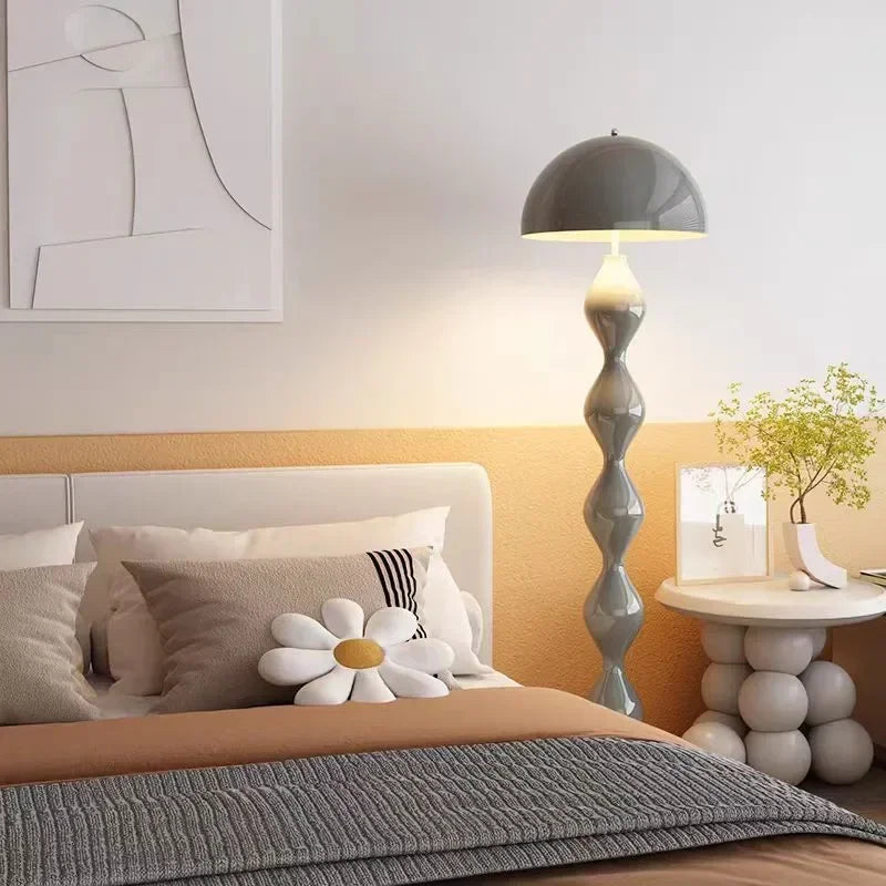 Modern bedroom with a bed, mushroom floor lamp, and side table.