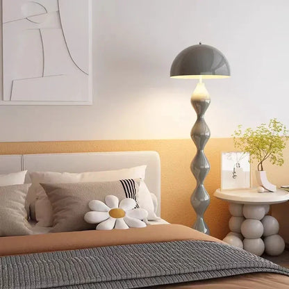 Modern bedroom with a bed, mushroom floor lamp, and side table.