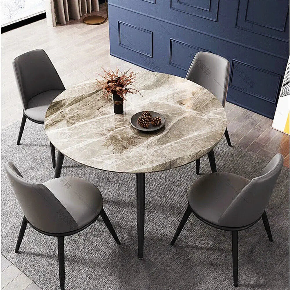 Luca brown Round marble dining table with four gray chairs in a room with blue walls.