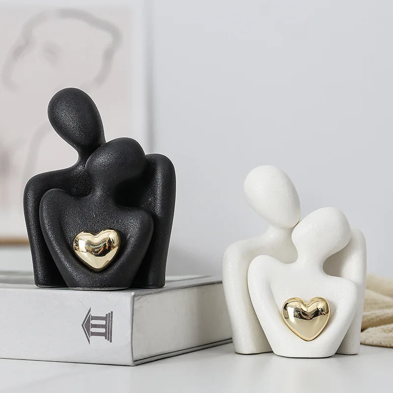 Black and white abstract sculptures with gold hearts on a light background