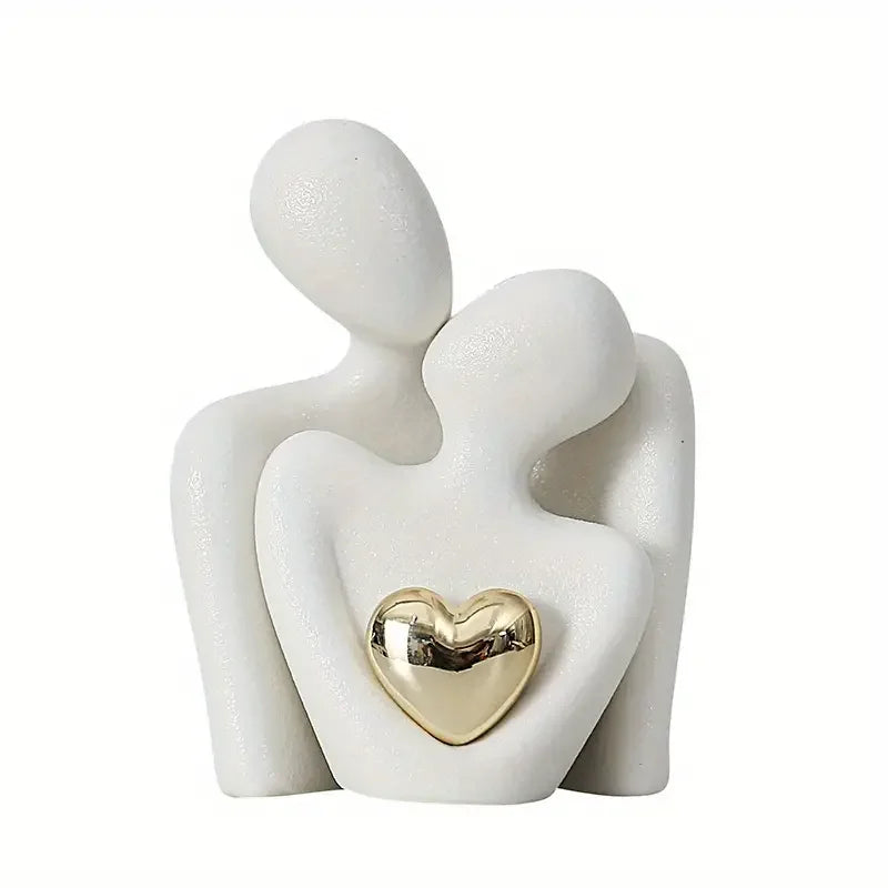 Ceramic figurine of two people embracing with a gold heart detail on a white background