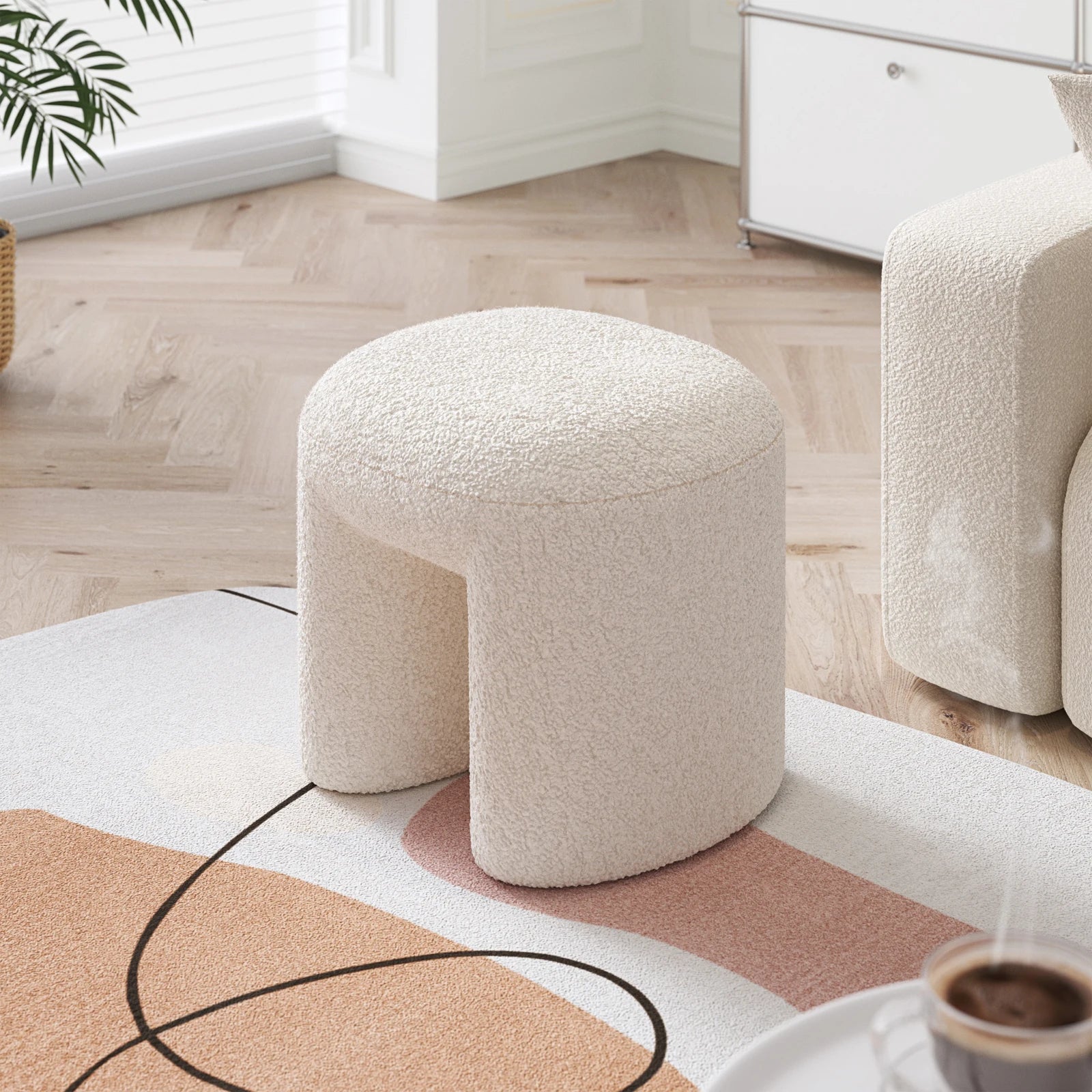 Round textured stool in a living room setting with a rug and chair.