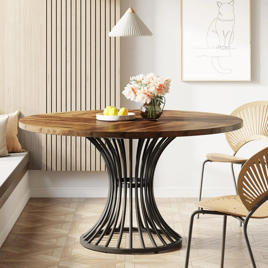 Round wooden table with black metal base in a modern interior setting