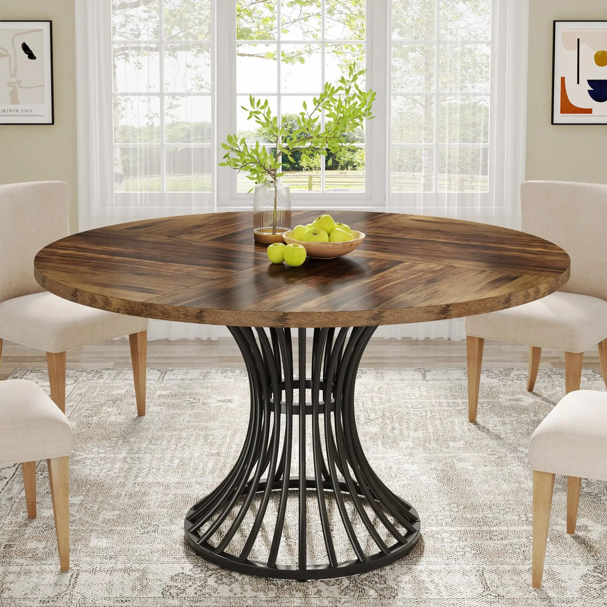 Round wooden dining table with black metal base in a bright room with chairs and decor.