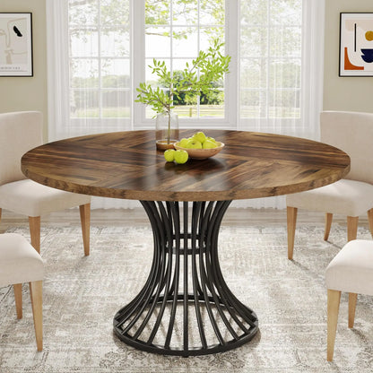 Round wooden dining table with black metal base in a bright room with chairs and decor.