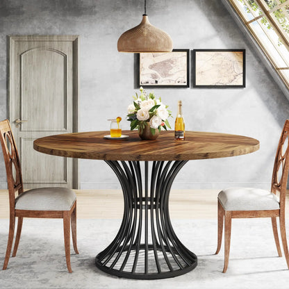 Dining table with wooden top and black metal base in a room with chairs and decor.