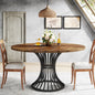 Dining table with wooden top and black metal base in a room with chairs and decor.