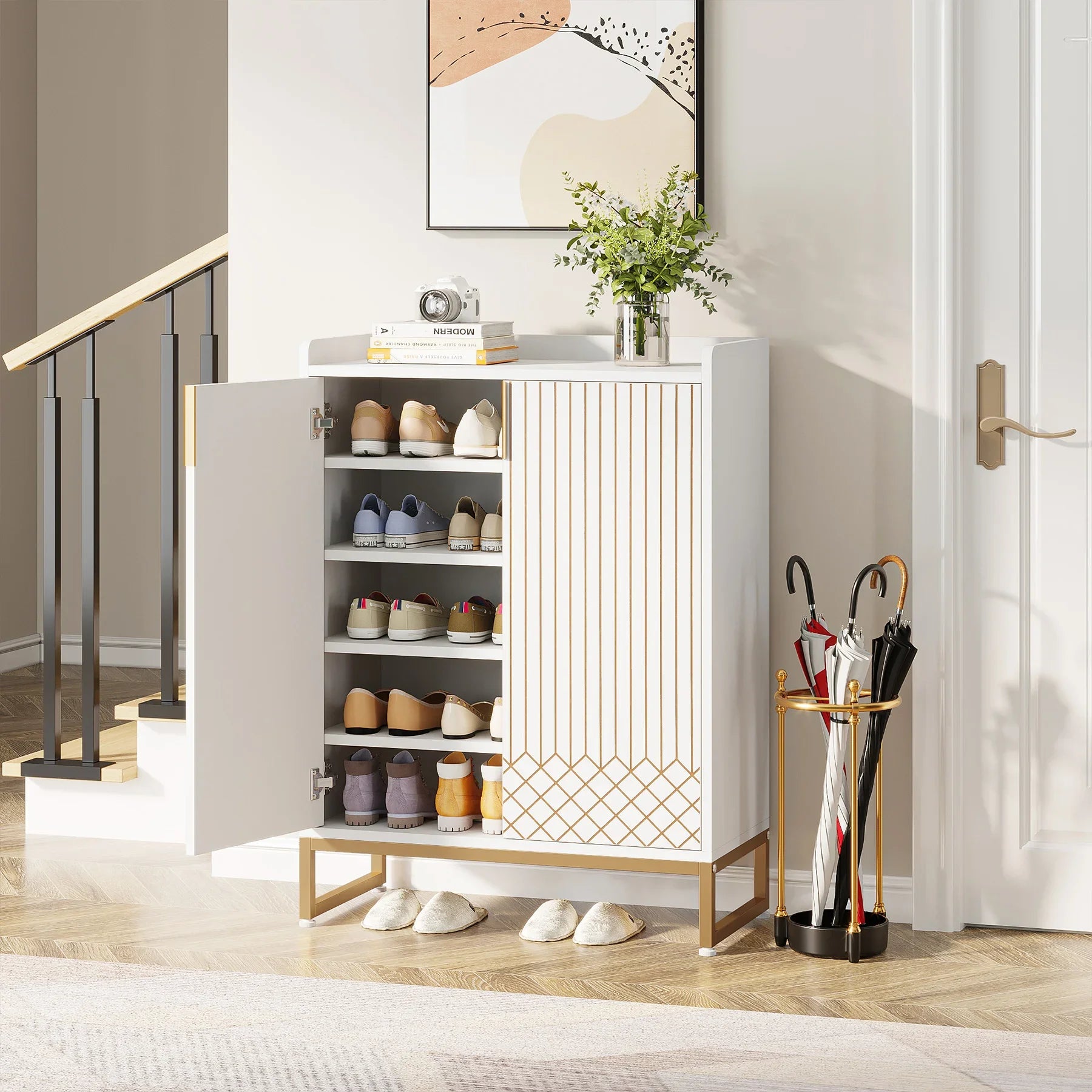 White shoe cabinet with open doors displaying shoes, next to a gold umbrella stand with umbrellas in a room.