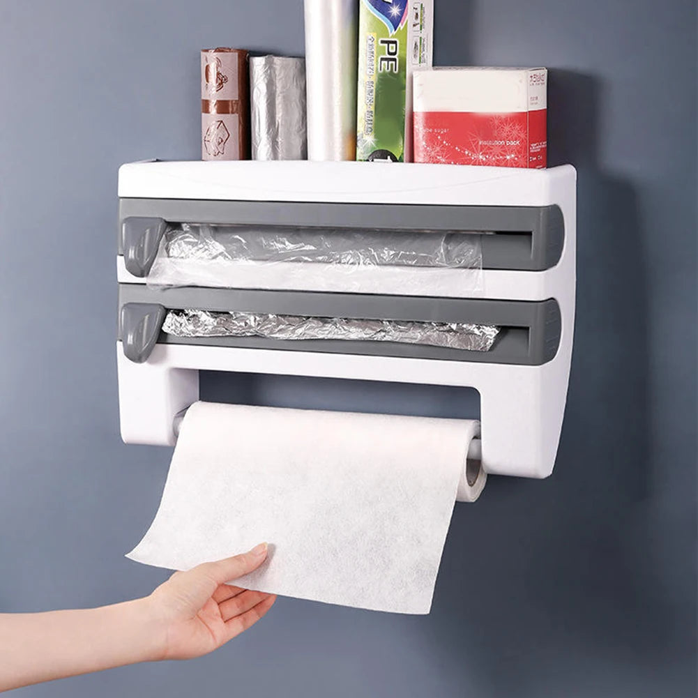 Wall-mounted paper towel holder with a hand pulling out a roll of paper towels against a gray background.