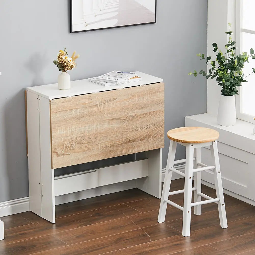 Wooden fold-out table in a room with a stool and decor items.
