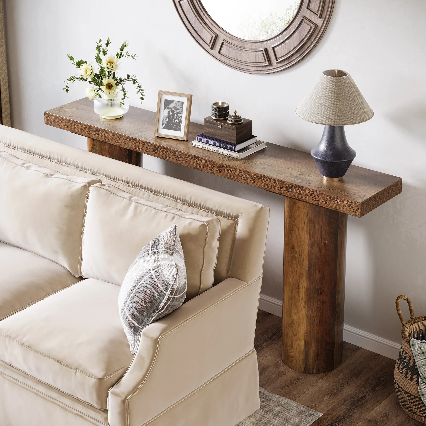 Beige sofa with decorative pillows next to a wooden console table with decor items.