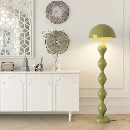 Green floor lamp in a room with decorative elements and a white cabinet.